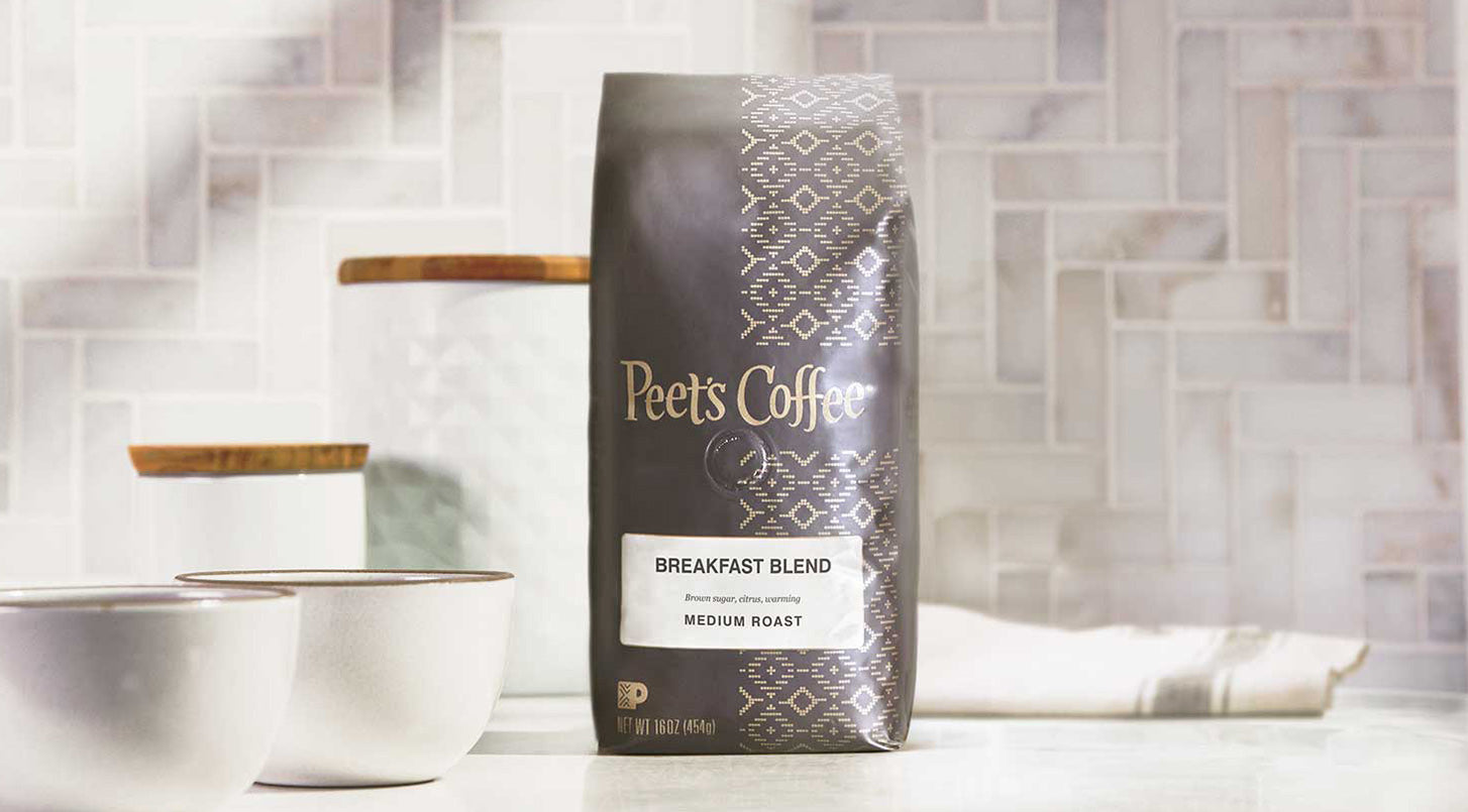 Peet's Coffee Breakfast Blend coffee beans bag sitting on a table with a light tile backsplash. 